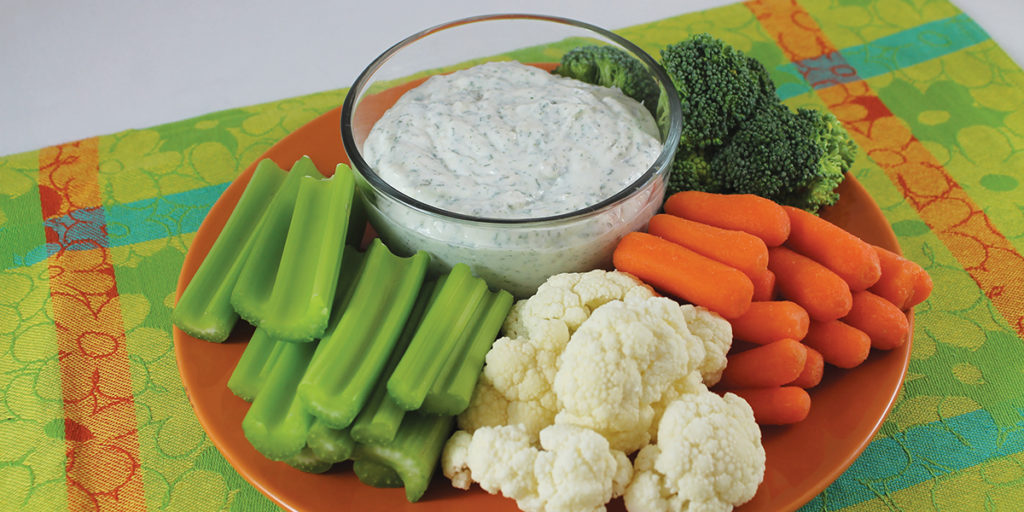 Homemade Ranch Dip plated with celery, carrots, broccoli, and cauliflower