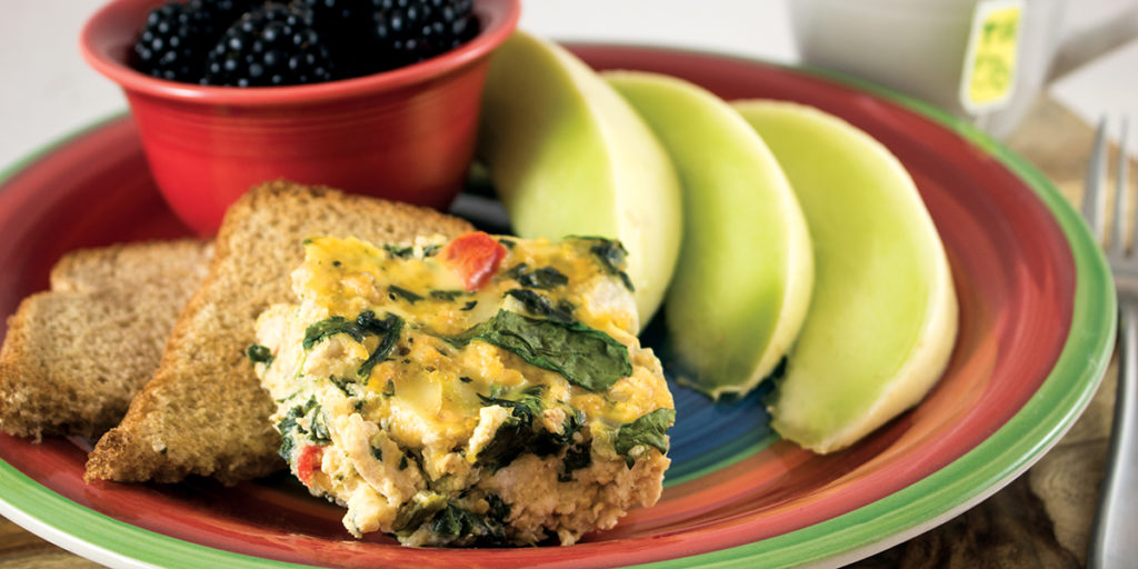 turkey breakfast bake plated with toast, melon, and blackberries