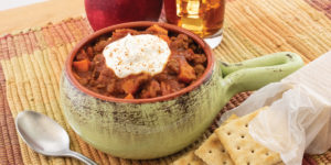 chipotle turkey chili plated with crackers and apple on the side
