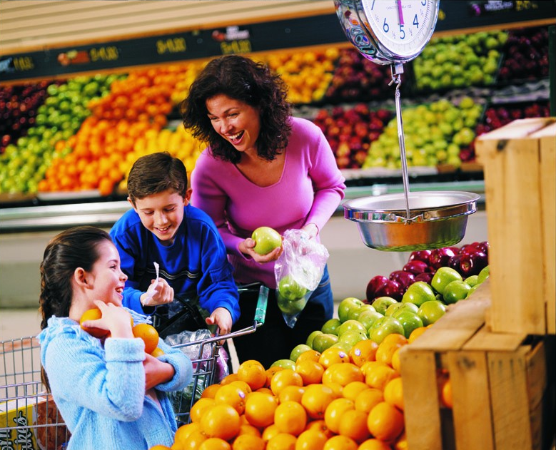 Mother and children shopping for fruit at the grocery store.
