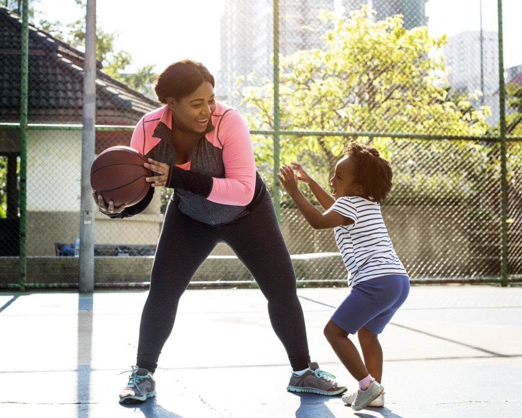 Mother and daughter playing basketball