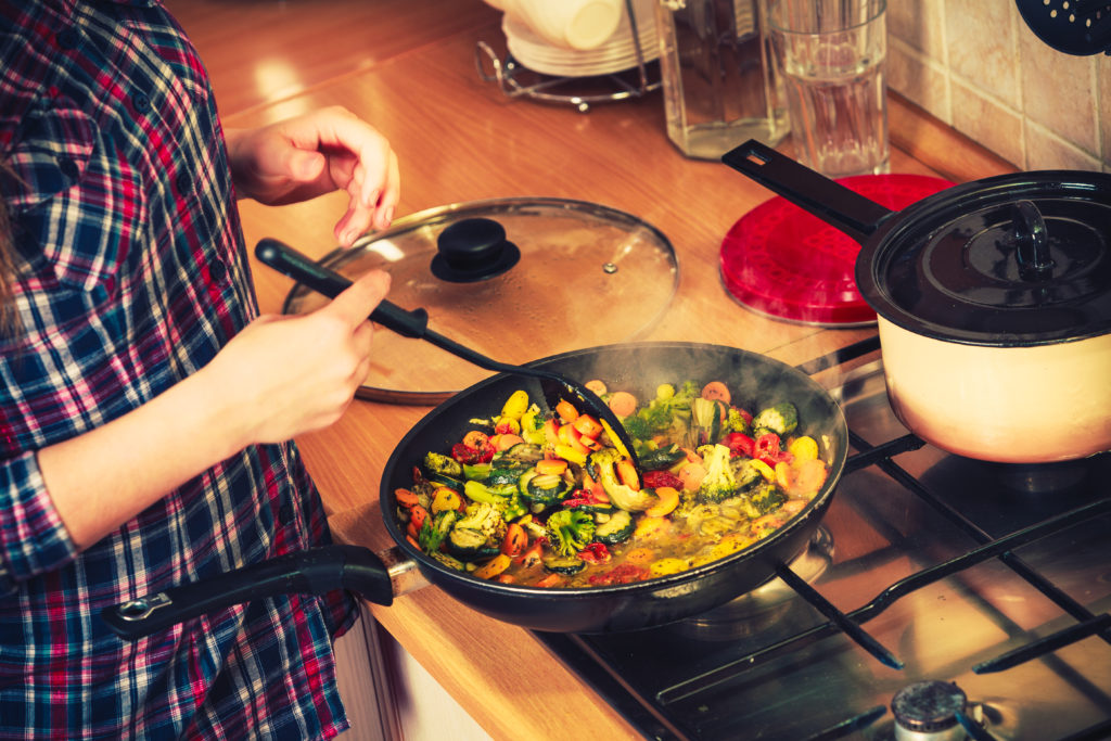 person sauteing vegetables