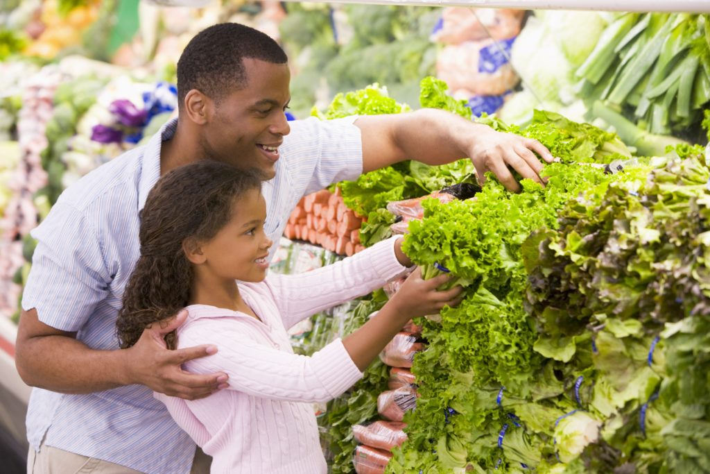 father and daughter picking out vegetables