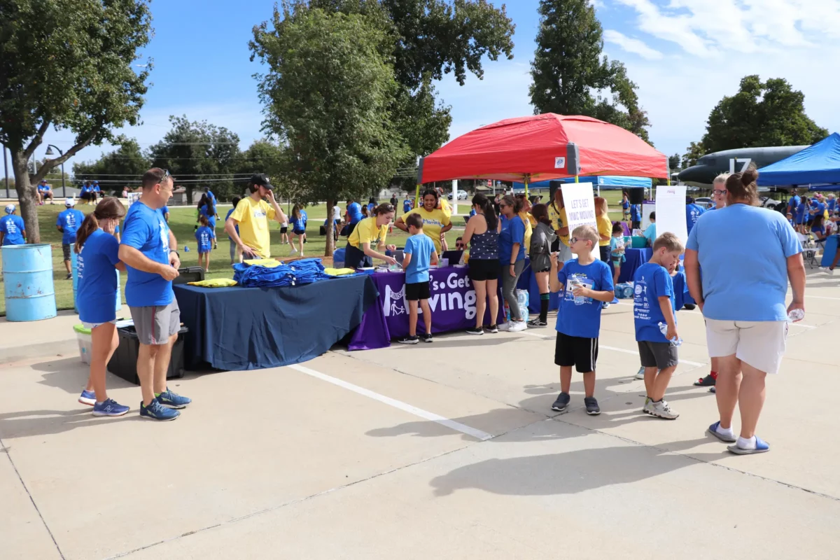 LGM participants are standing in front of tables at the event's expo fair.