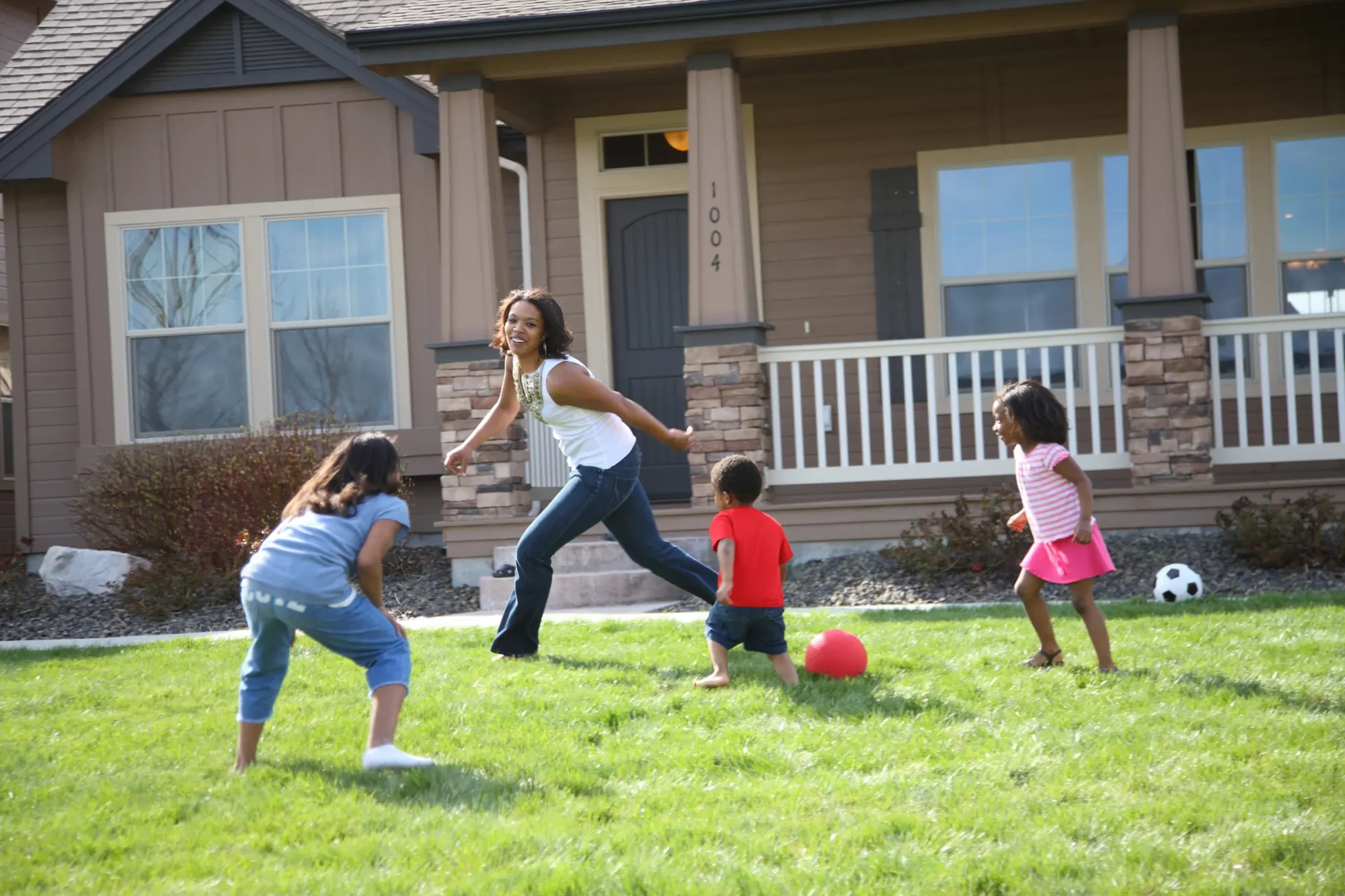 A family runs around in their yard, playing together.